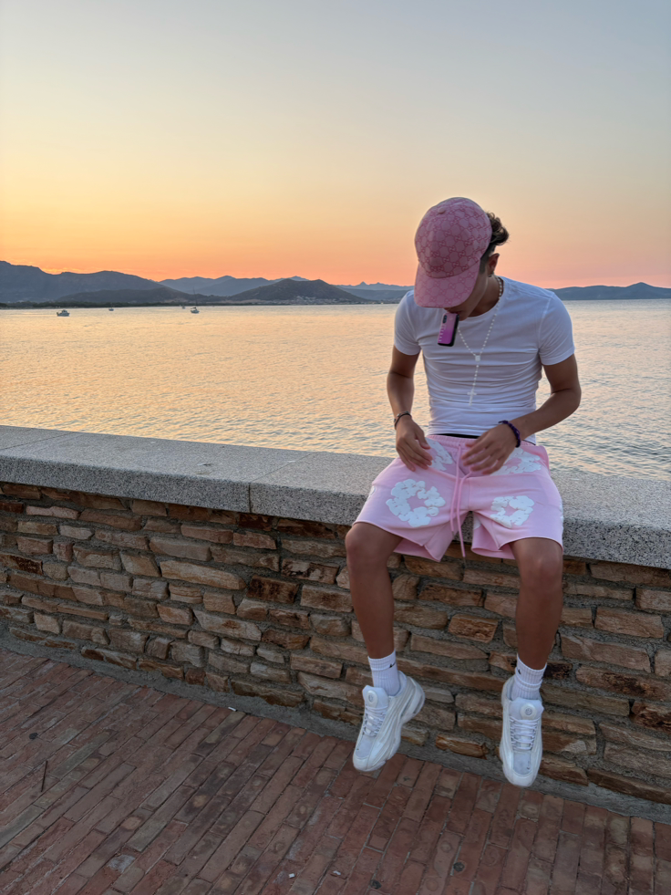 White tee with pink denim tears shorts at sunset